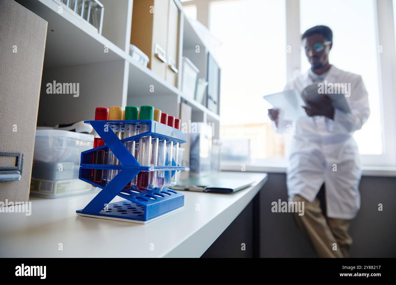 Close up on multiple test tubes with blood or chemicals on plastic rack ...