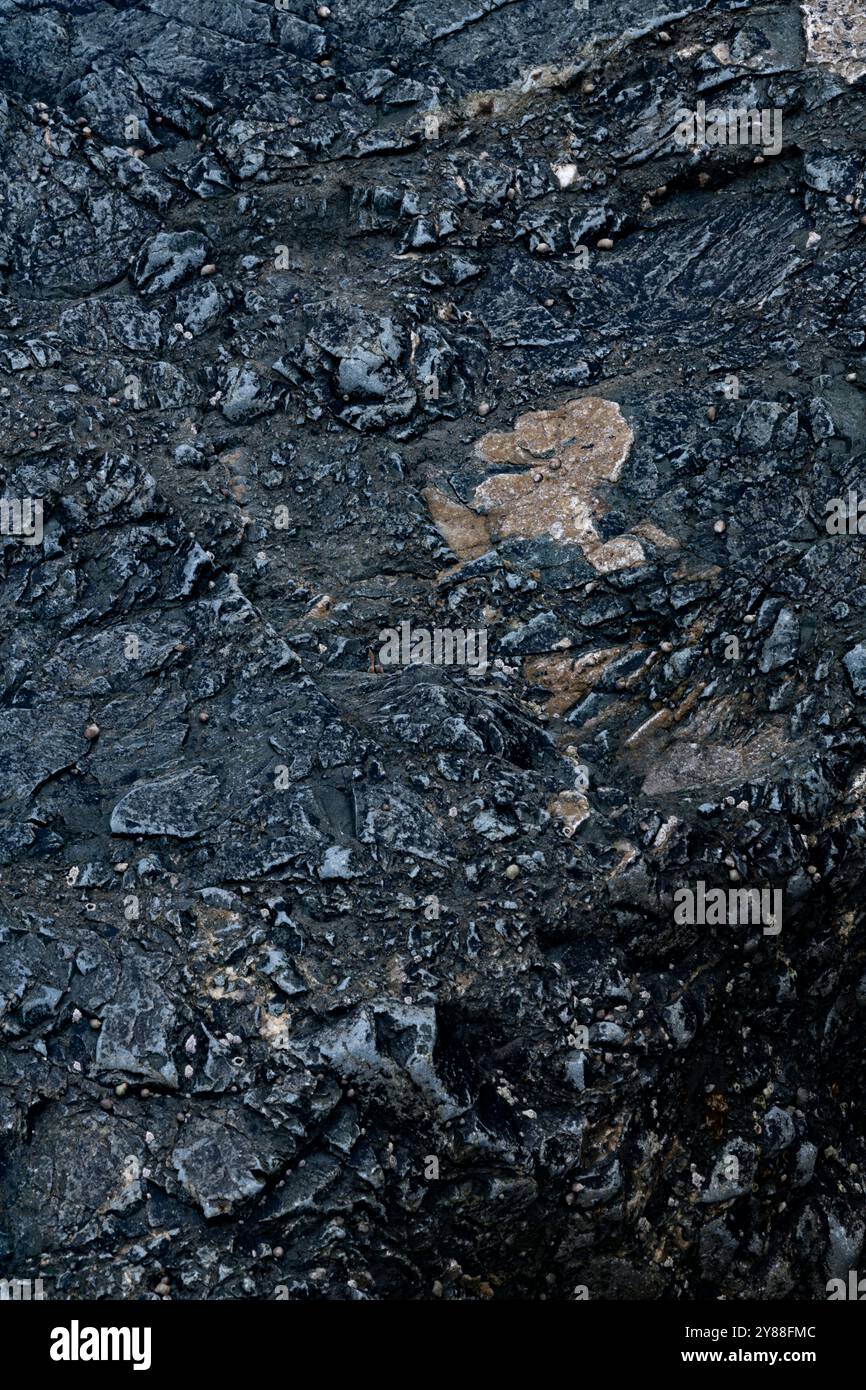 Dark Stone Texture with Jagged Patterns on Bunmahon Beach, Ireland Stock Photo