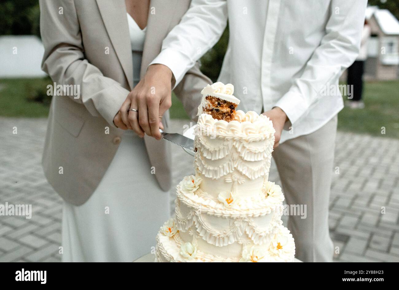 A beautifully crafted wedding cake stands tall, showcasing intricate ...