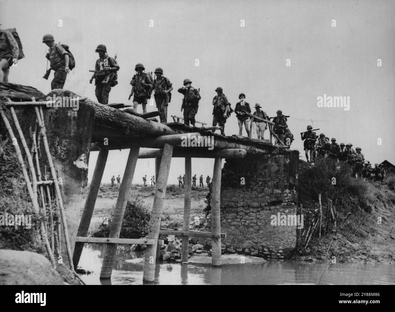 French paratroops dropped near Cho-Ben, Indo-China, during a November 10 surprise attack backed by French and Vietnam ground forces and artileery, cross, a small bridge which was left standing by the disconnected and retreating Viethminh rebel force. As the paratroops mopped up the Rebel settlement, a column moved up from the south and another hurried down from the north in a giant pincer movement which caught many pockets of retreating troops - at the village of doy-couy, some 30 miles South of Hanoi, The Vietnam left nearly 200 dead. November 28, 1951. Stock Photo