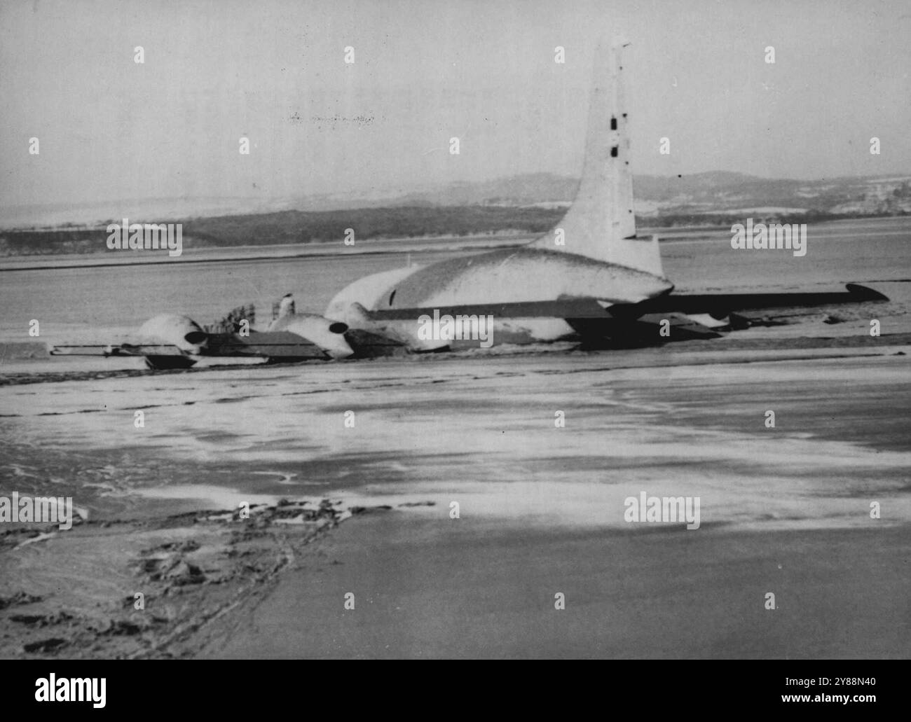 'Britannia' In The Mud After Severn Crash -- The Bristol Britannia, Britain's huge new turboprop airliner, lying embedded in the mud at Littleton-on-Severn after crashing into a River Severan mud bank to-day (Thursday).One of the plane's four engines was ablaze and a fuel tank blew up. Fourteen persons on board were able to wade ashore, but one had to go to hospital. The Britannia, the second one built, had taken off from Filton airfield, Bristol, on a routine test flight. It was piloted by Captain A.J. (Bill) Pegg, 42 years-old chef test pilot of the Bristol Airplane Company. February 01, 195 Stock Photo