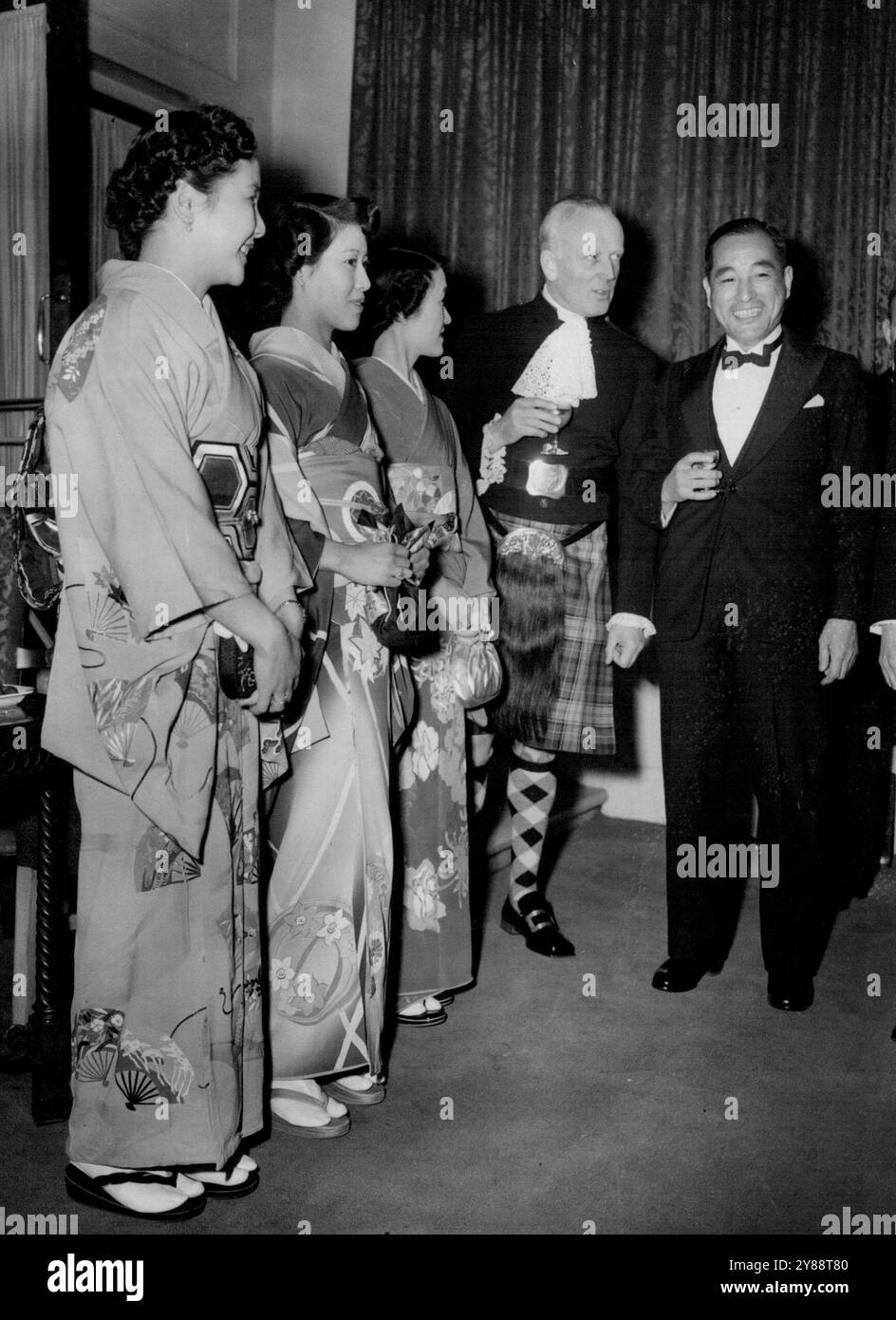 Japan Celebrates In LondonMr. Koichori Asakai with a kilted Scottish guest, Lord Sempill, at the party. Wearing the national costume of Japan in foreground are lives of the Japanese diplomatic mission left to right: Mrs. Asakai, wife of the Charge d'Affaires; His, Fujisaki; and Mrs. Suzaki. The 51st birthday of the Emperor Hirohito of Japan was celebrated in London to-night (Tuesday) when a dinner party was given by Mr. Koichori Asakai, the Japanese Charge d'Affaires, and Mrs. Asakai to leading members of the Japan Society in Great Britain at Grosvenor House, Park Lane, London.Mr. Asakai, who Stock Photo