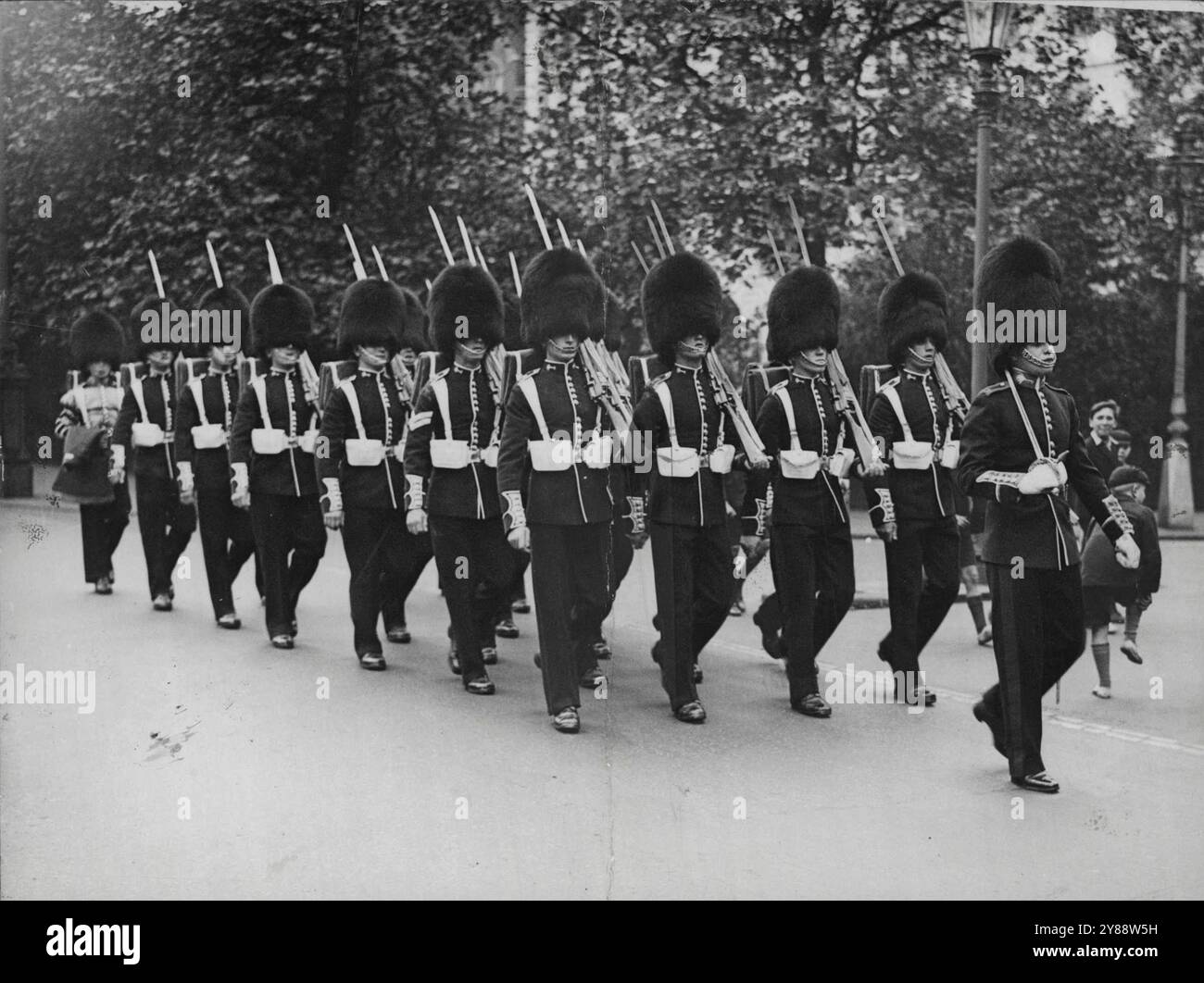 The Guardians Of England Money -- The Guards photographed on route for the Bank of England to ***** over the Guard. The Task of guarding England's money at the Bank of England is undertaken each night by Member of H.M. Brigade of Guards who march through the streets of London from Wellington Barracks to the Bank of England. July 30, 1934. (Photo by Universal). Stock Photo