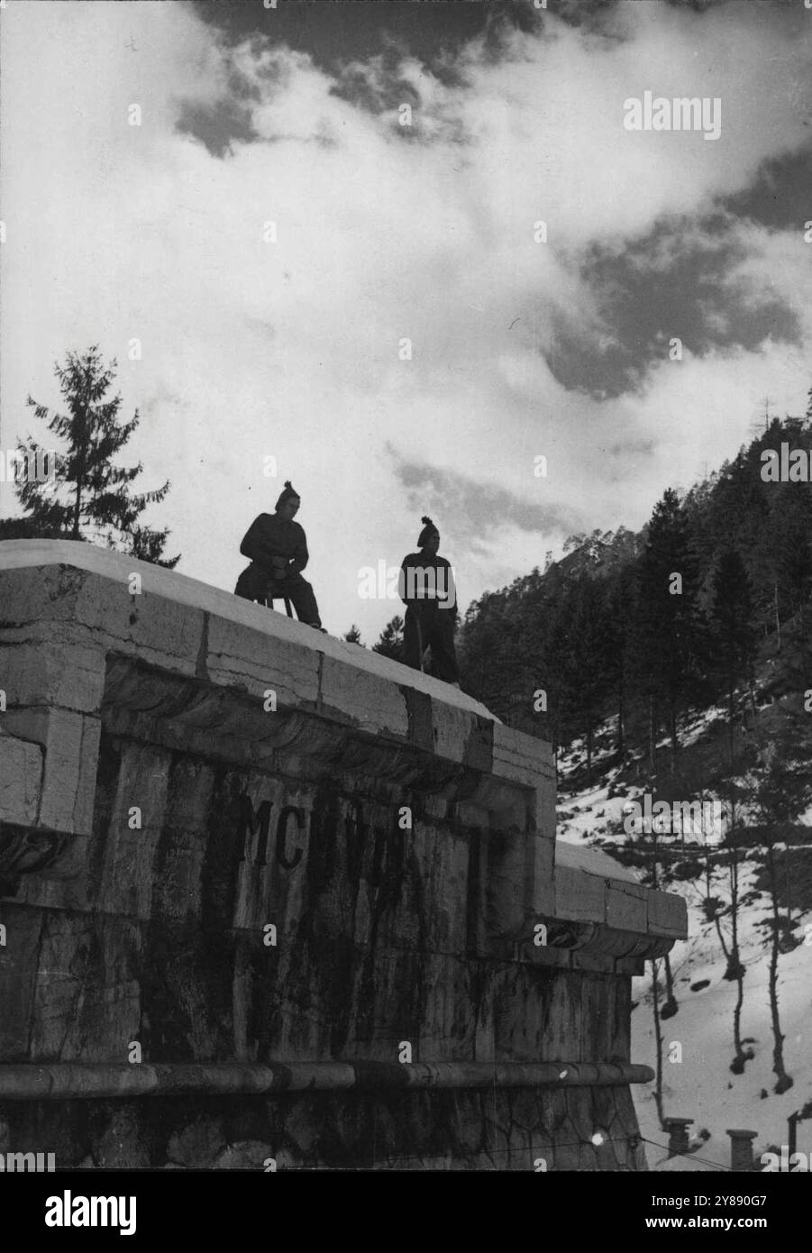 A Lonely Vigil In A Lovely Land -- At the end of the campaign against the Hazis, Marshal Tito chose the very stool on which Fusilier Pat Sullivan of Norwich is seated on the top of the entrance to the Karawanken Tunnel, to view what is probably one of the finest panoramas in Australia. No Doubt, his sergeant, Peter Lynch of Dunlin, prefers the emerald field of Ireland.Watching high among the mountains of Southern Austria 'The Frontiersmen' are watching. At the little village of Rosenbach, on the Austrian side of the Austro-Yugoslav border, men of the Royal Irish Fusiliers maintain guard over t Stock Photo