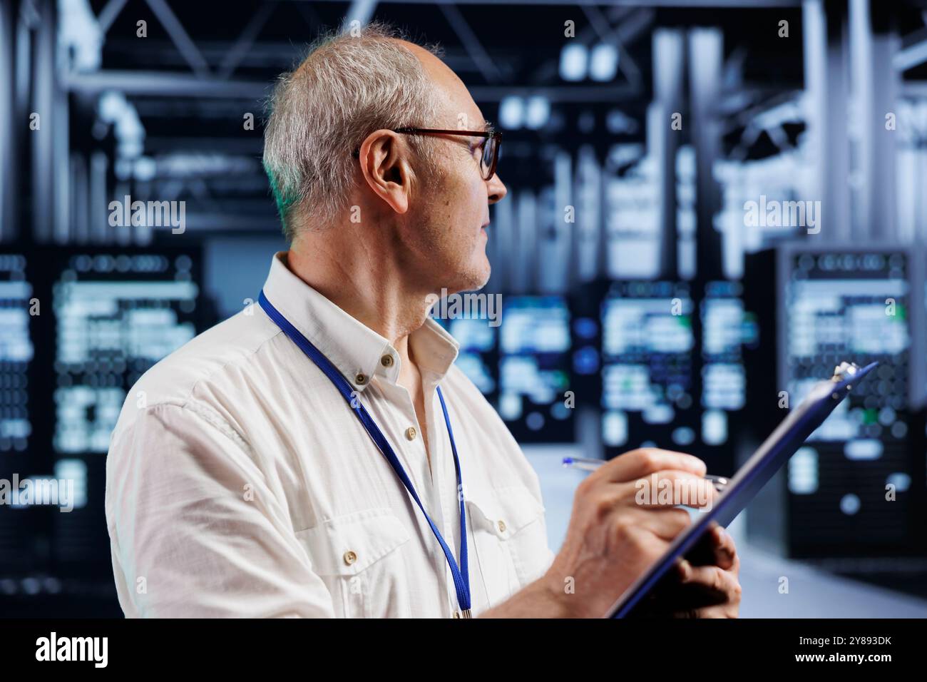Elderly engineer in crypto mining farm with specialized hardware using Blockchain technology. Fintech expert holding clipboard, inspecting asic rigs solving complex computational problems Stock Photo
