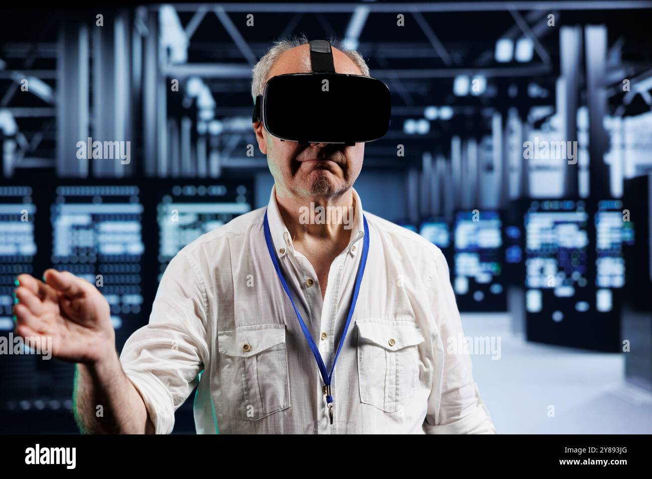 Old developer immersed in virtual reality at data center, doing hardware maintenance. Professional using VR headset to optimize server rows system performance, harnessing cutting edge technology Stock Photo