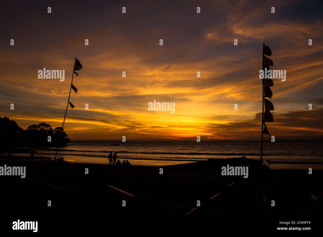 sunset on the beach with silhouette of flags and humans Stock Photo - Alamy