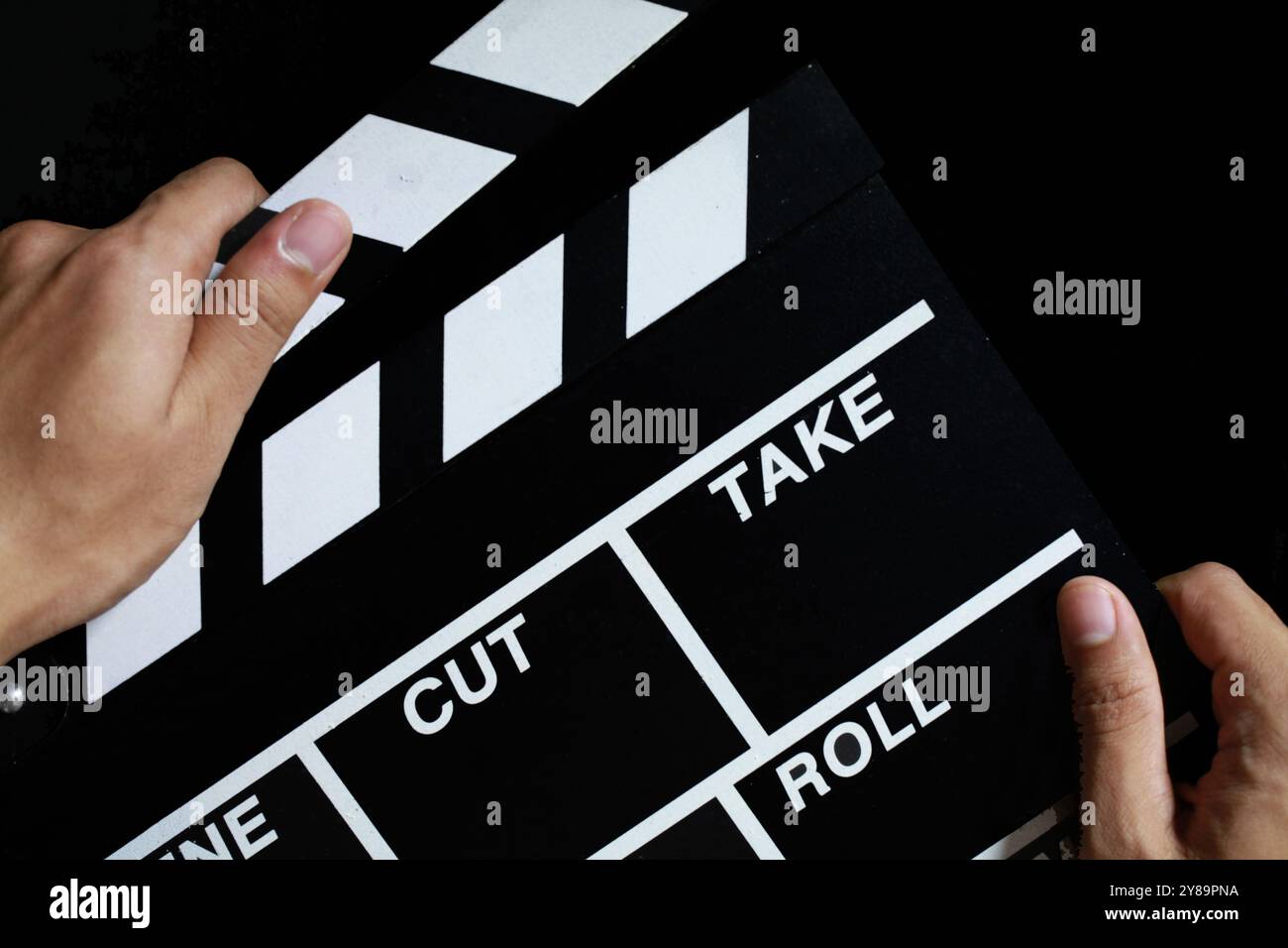 hand hold clapperboard on black background Stock Photo