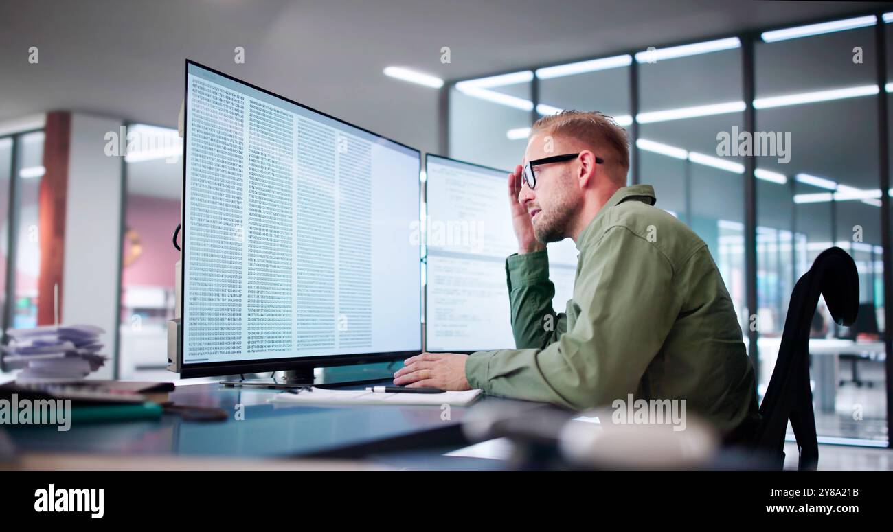 Unhappy Sad Developer Programmer Man In Stress Coding Software On Computer Stock Photo