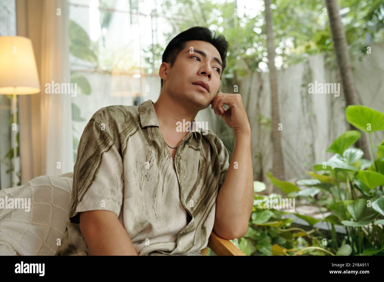 Pensive Man Looking Through The Window Stock Photo