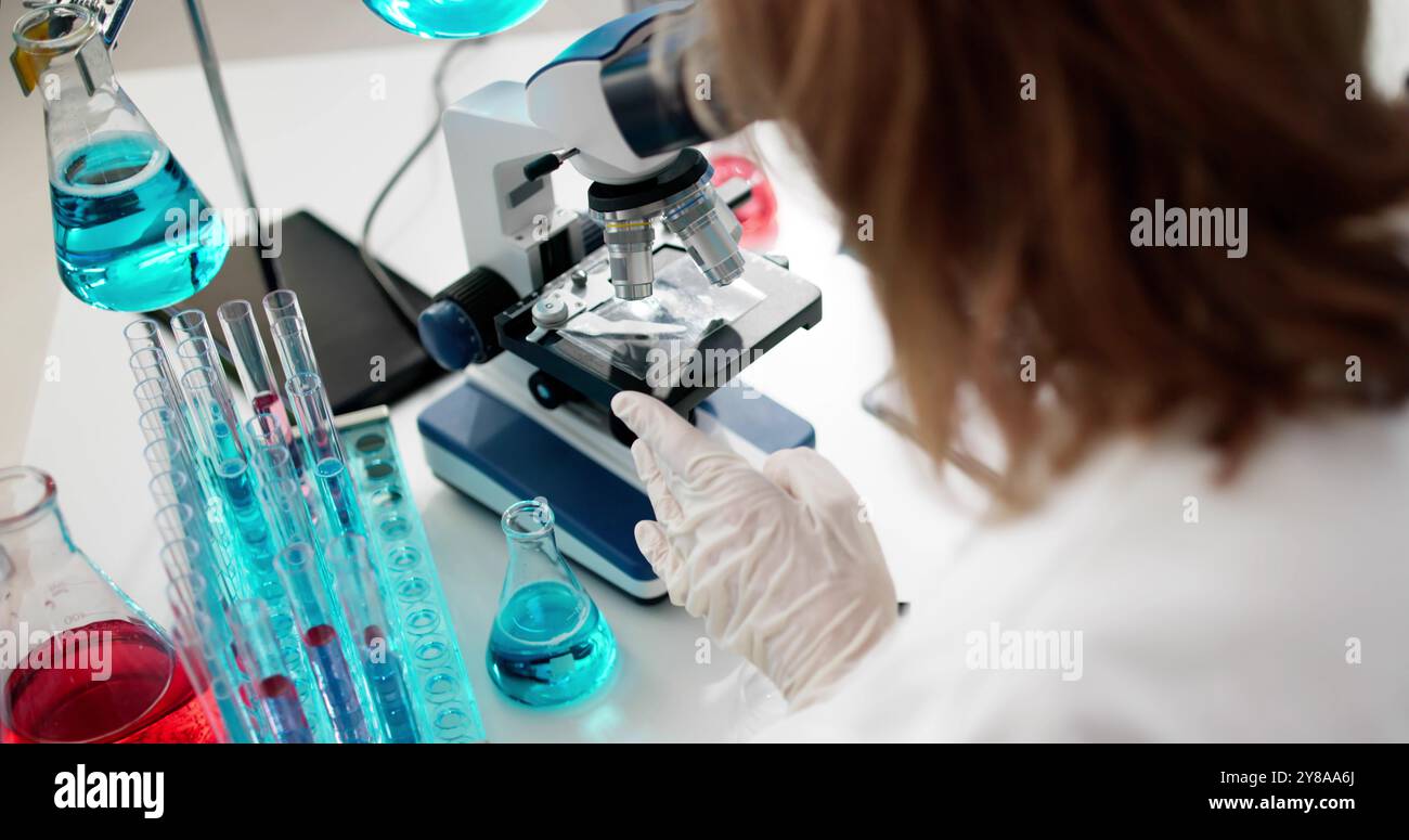 Older Female Scientist In Lab With Microscope Stock Photo