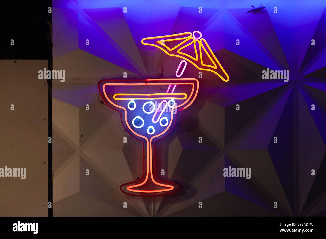 A neon sign outside of a Cocktail Bar shaped like a cocktail glass. Stock Photo