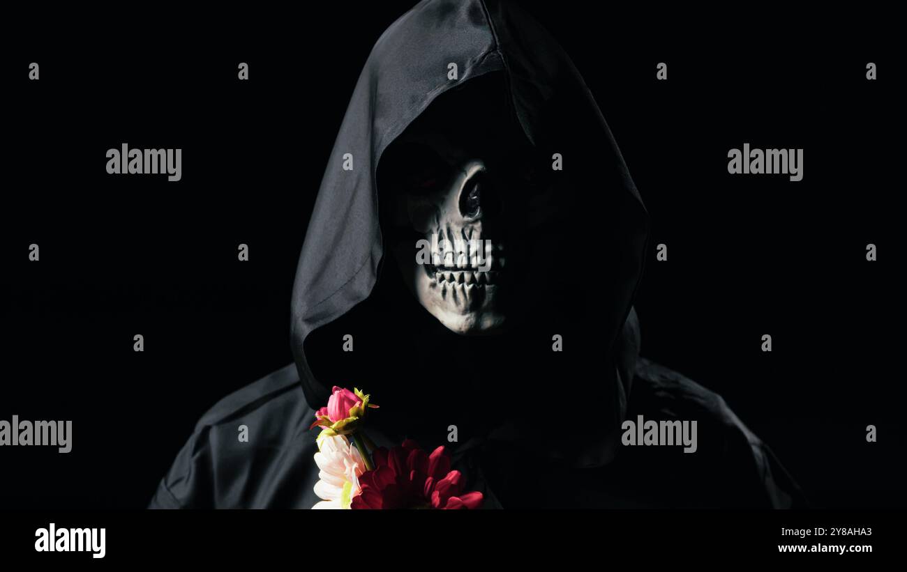 Dead man mask holding the flowers  Stock Photo