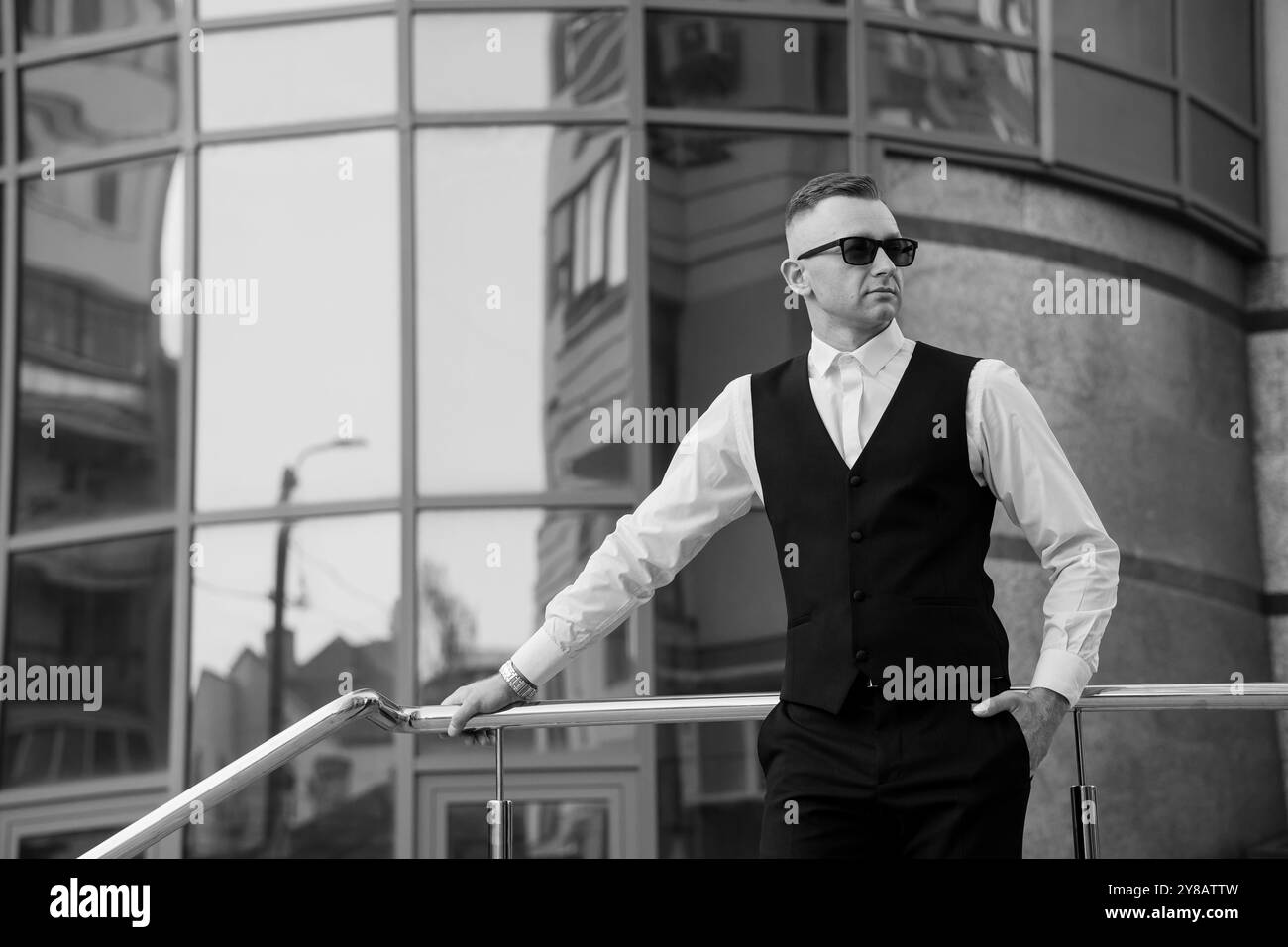 Stylish Young Man in Black Suit with Sunglasses Posing Confidently ...
