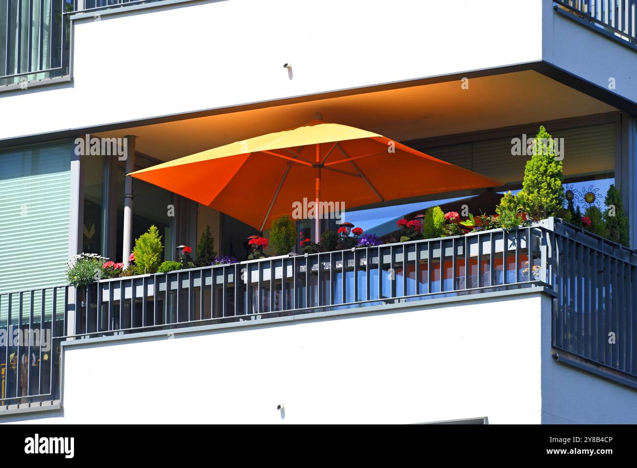 Orange parasol on a balcony in Bergedorf, Hamburg, Germany, Oranger Sonnenschirm auf einem Balkon in Bergedorf, Deutschland Stock Photo