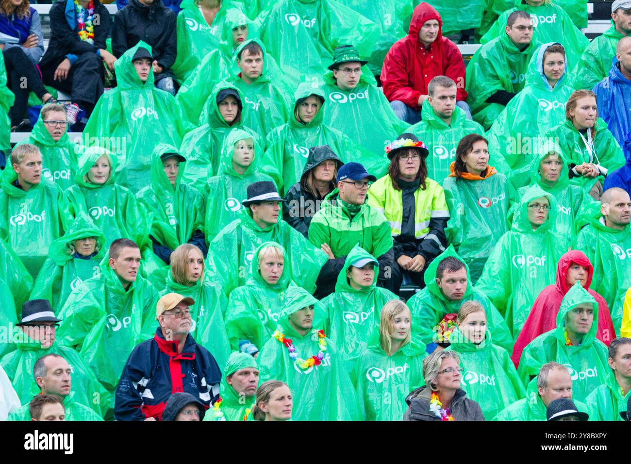 SUMMER STORM, BEACH VOLLEYBALL, MARIEHAMN, 2011: The crowd cover up with disposable rain ponchos as a huge summer storm sweeps through the stadium with a deluge of rain during the semi-finals in August 2011 at the Paf Open in Mariehamn, Åland, Finland. Photograph: Rob Watkins.   INFO: Between 2009-2013 the PAF Open Beach Volleyball tournament was an annual event held in Mariehamn, Åland, Finland. It attracted the top international teams and players as a ranking part of the official FIVB World Tour, showcasing high-level beach volleyball. Stock Photo