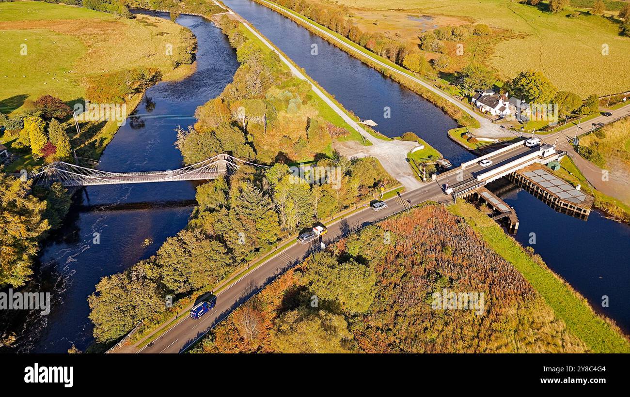 Bridge of Oich or the Victoria Bridge Aberchalder Scotland a white suspension bridge the nearby Caledonian Canal and Swing Bridge and A82 road in late Stock Photo