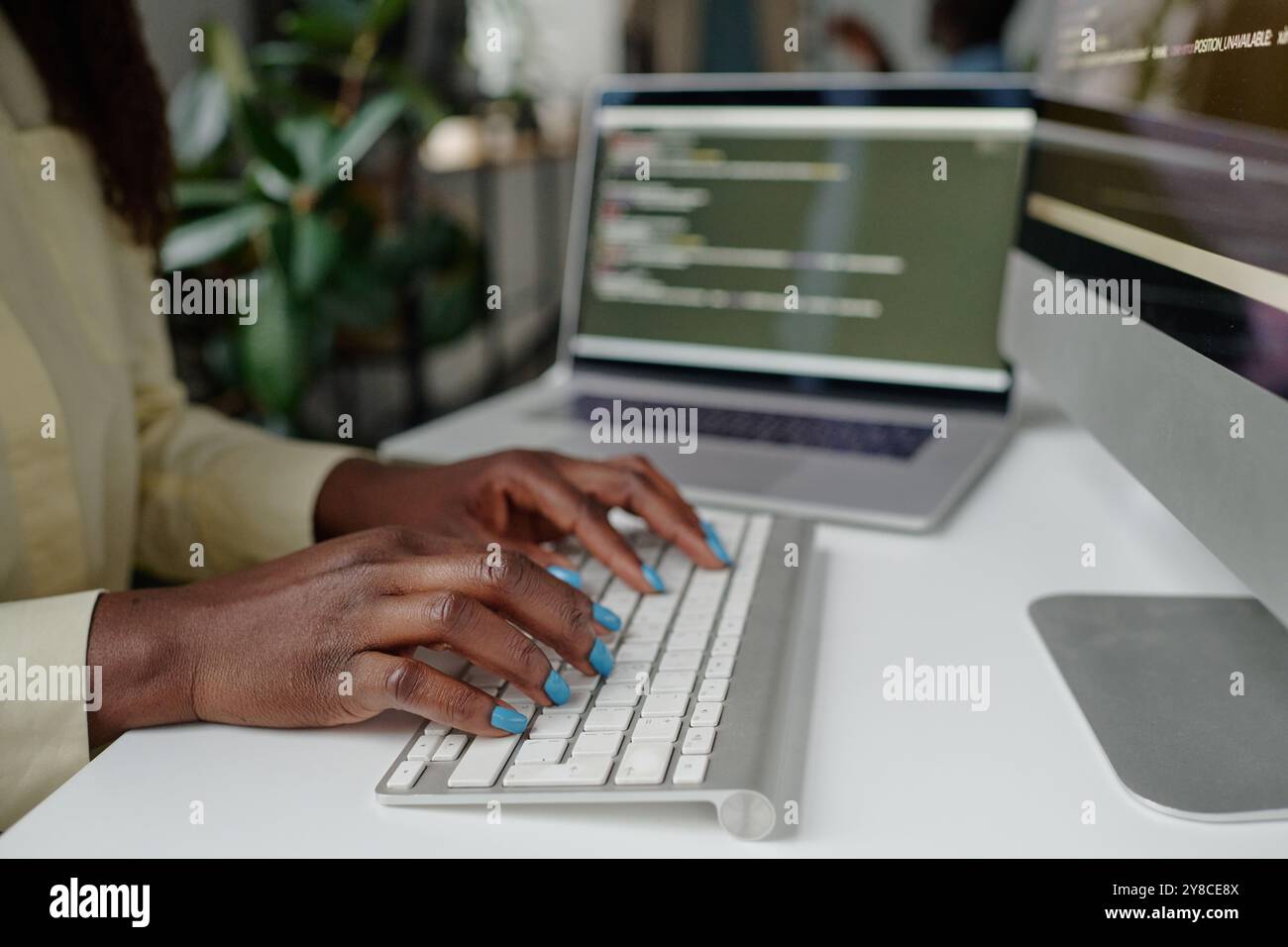 Medium close up of manicured hands typing on white keyboard Stock Photo