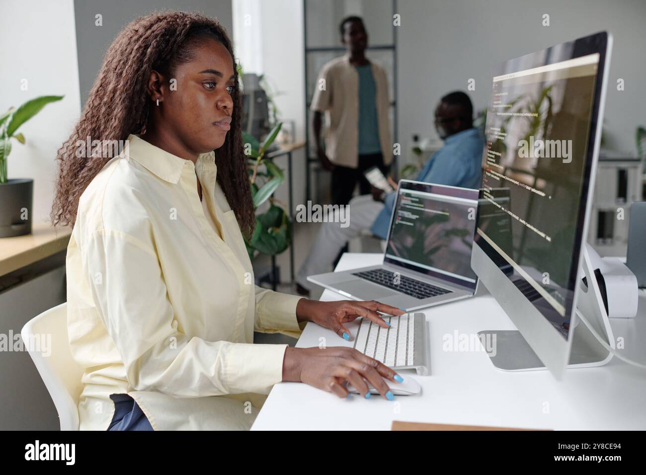 African American woman focused on programming, she writing codes Stock Photo