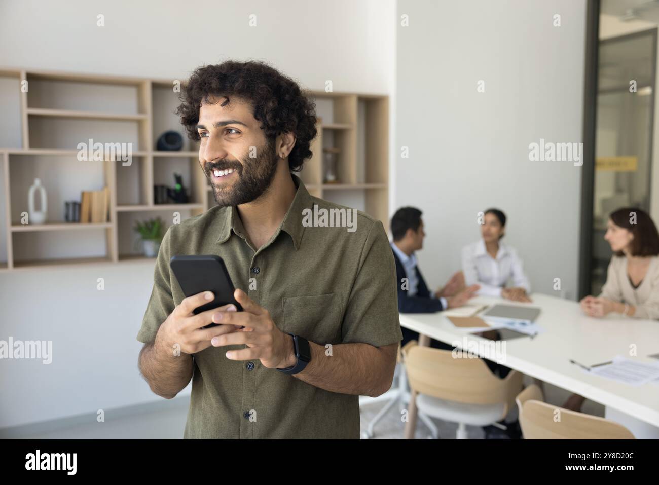 Young Arabian guy take break in work enjoy using smartphone Stock Photo
