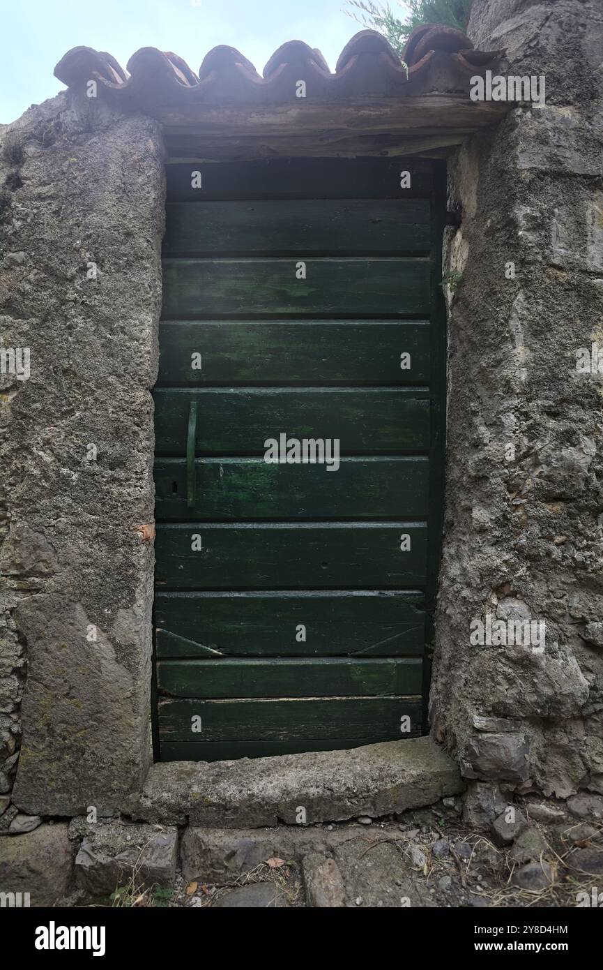 Wooden door in a stone wall in a town Stock Photo - Alamy
