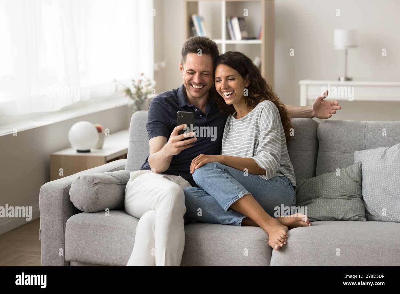 Cheerful married couple using application on mobile phone Stock Photo
