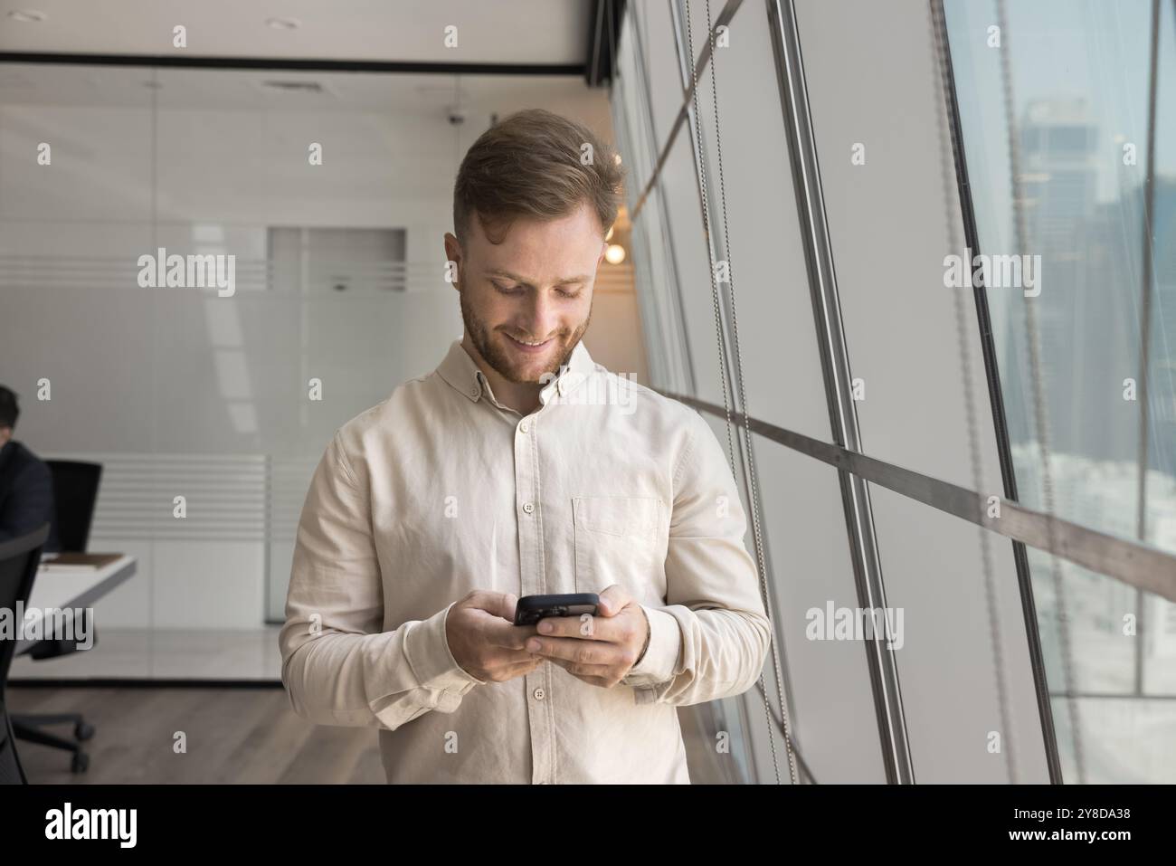 Positive focused young businessman in casual using financial application Stock Photo