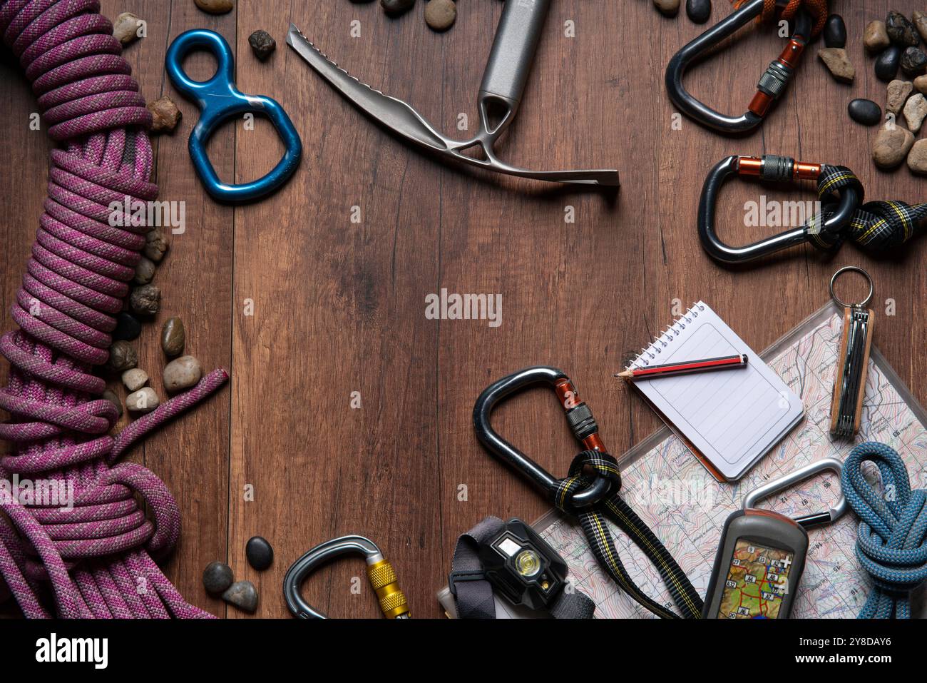 Top view of wooden table with climbing equipment, rope, carabiners, ice ...