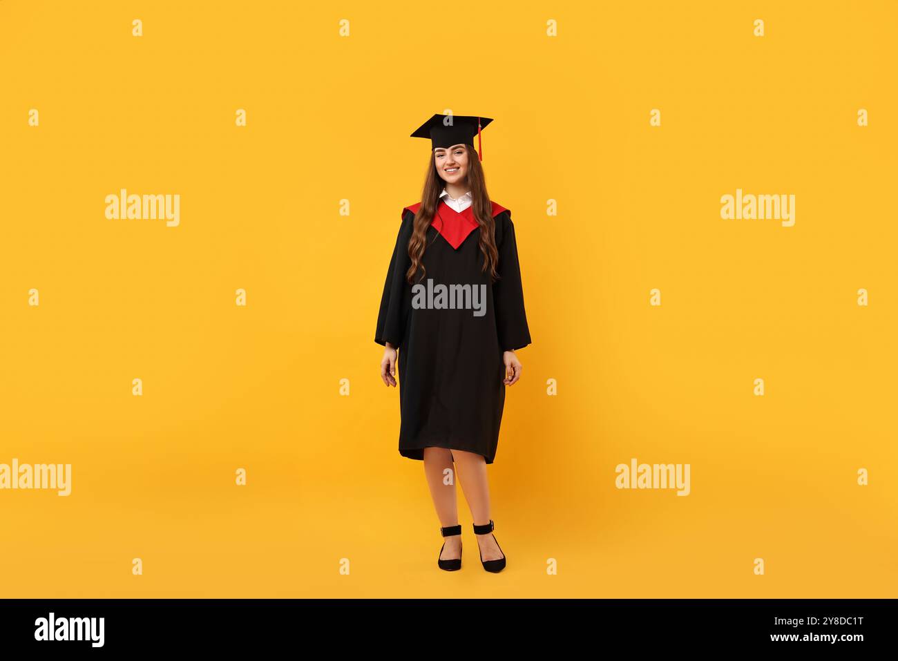 Happy student after graduation on orange background Stock Photo - Alamy