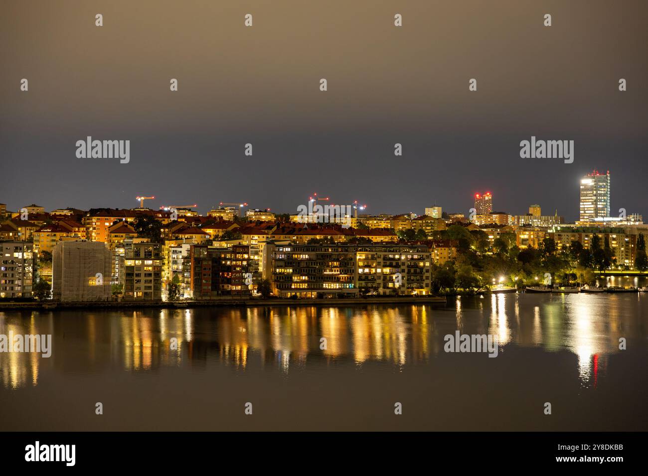City skyline at night with illuminated buildings reflecting on water ...