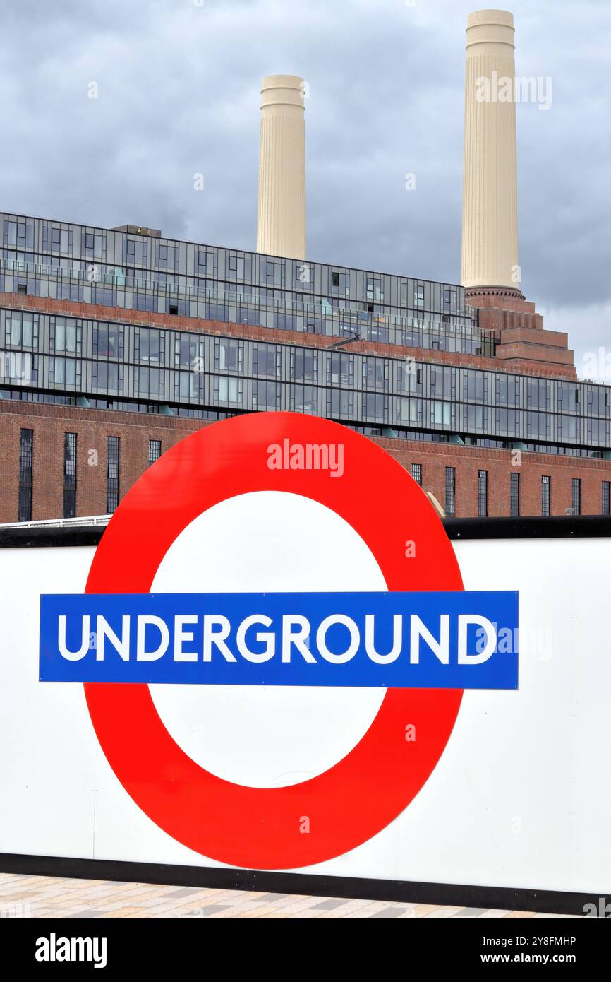 A large sign of the London Underground with Battersea Power Station in the background Stock Photo