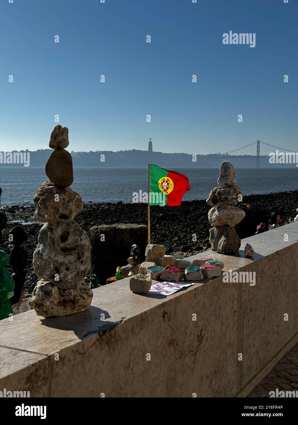 Portuguese flag between two stacks of rocks on the shore of Lisbon. - Smartphone Captured Stock Image