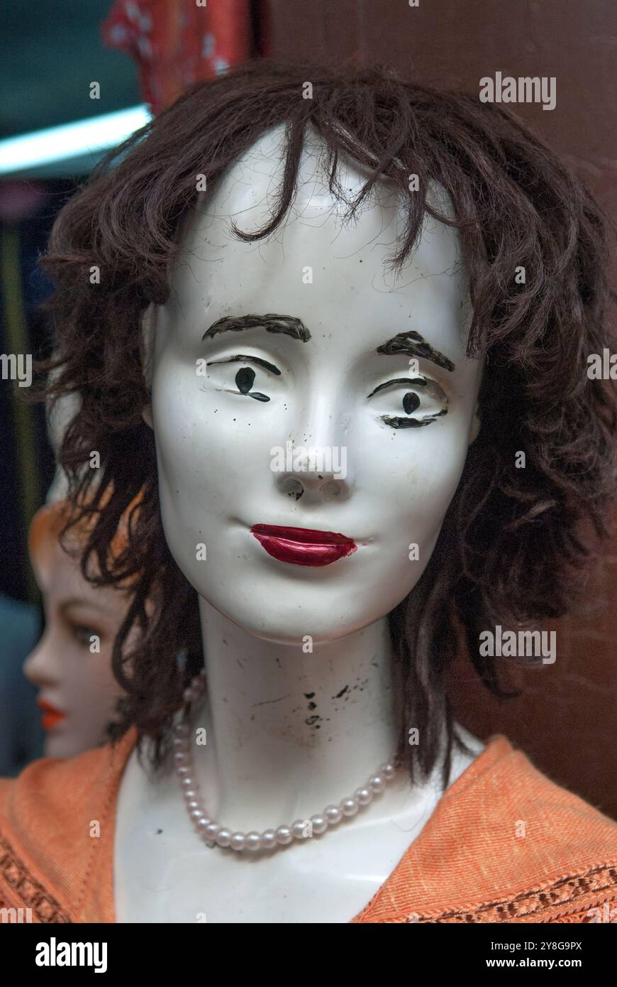Damaged shop second hand mannequins in the tourist market, Fez el Bali, Morocco, North Africa, circa August 2007. The shop keepers have added makeup, painting in eyebrows, making the lips very red, having fun giving these faces some character. HOMER SYKES Stock Photo