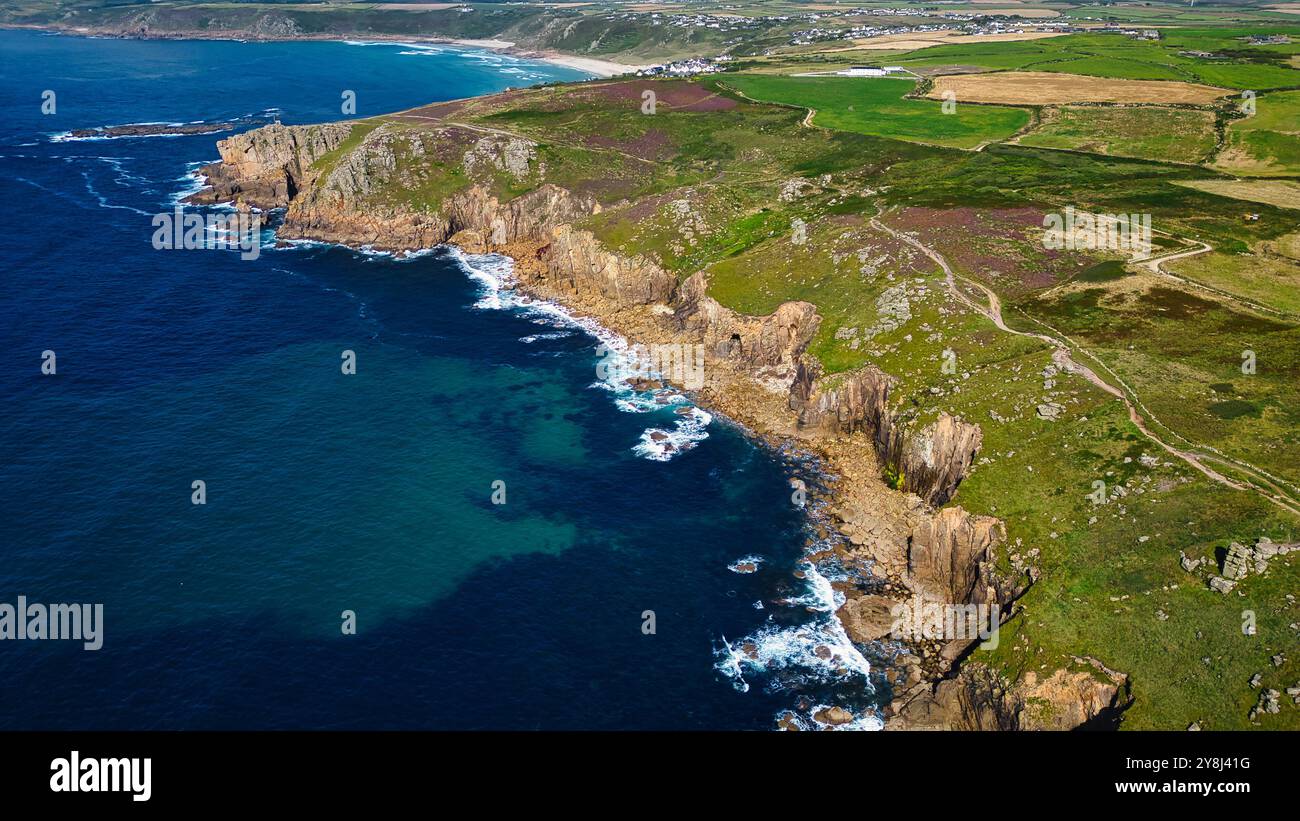 Aerial view of a rugged coastline with cliffs, clear blue waters, and ...
