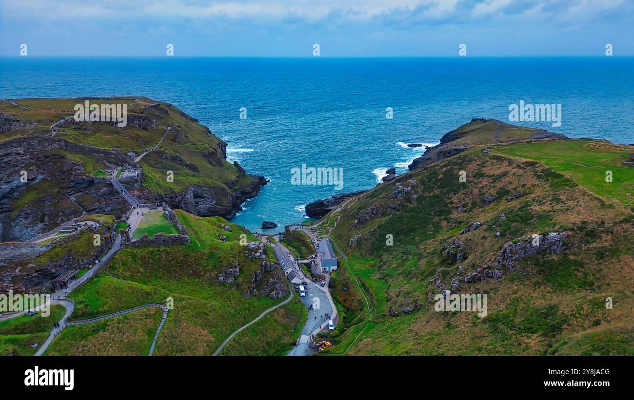 Aerial view of a coastal landscape featuring rugged cliffs, a winding ...