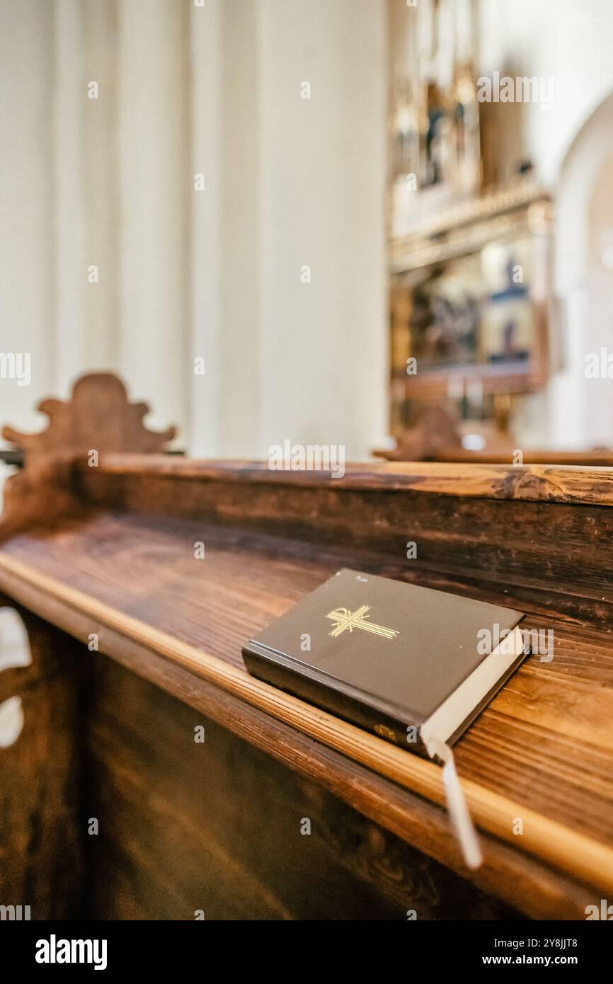 Bible on a wooden chair in the Catholic church close-up Stock Photo - Alamy