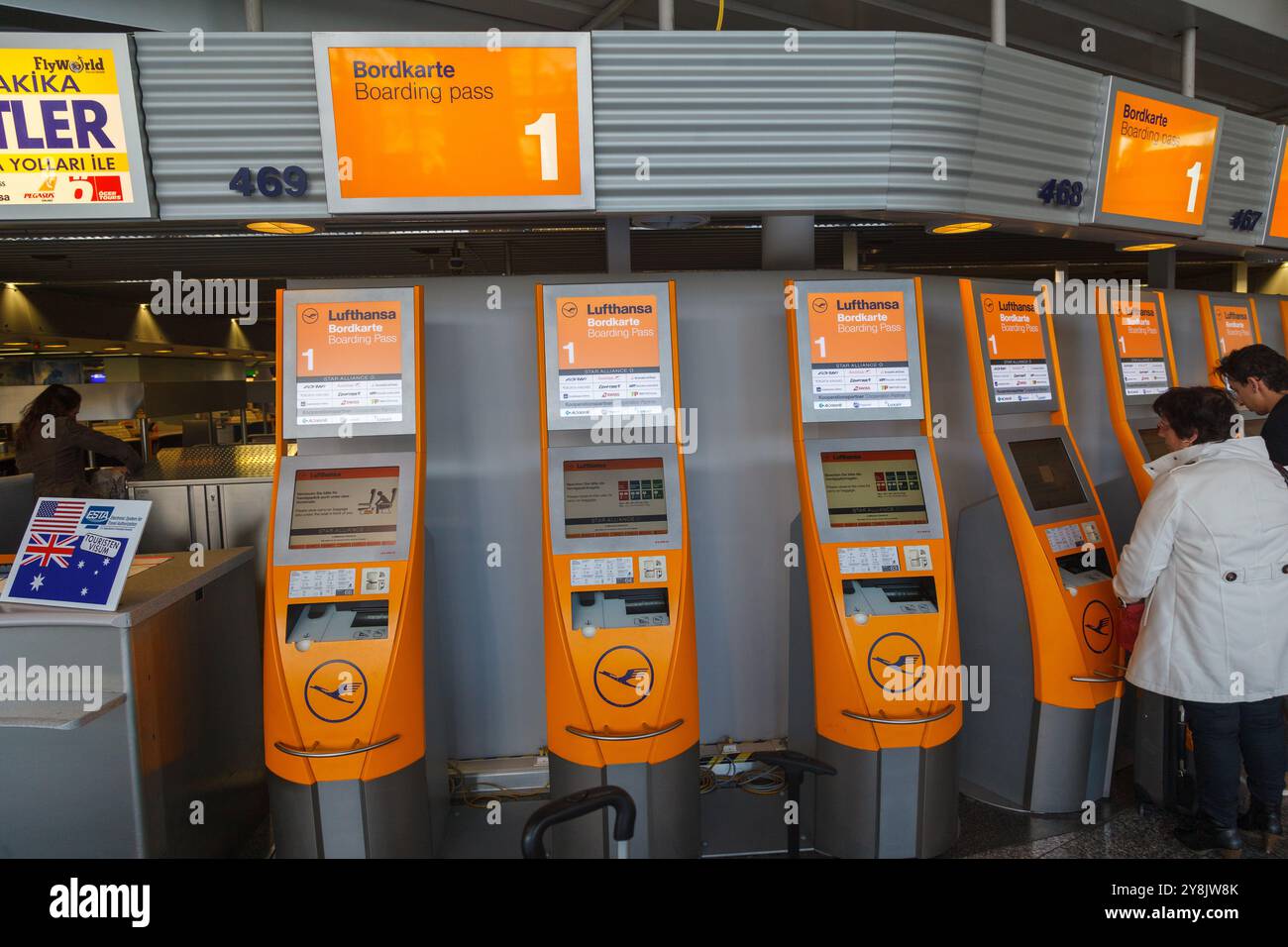 Passengers using a set of auto check-in machines of Lufthansa inside Frankfurt airport, Germany. Stock Photo