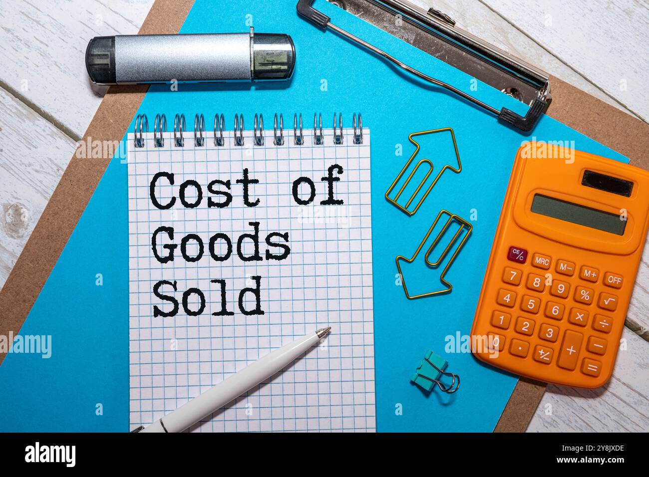 Phrase cost of goods sold written on note book with calculator and fake money. Business and finance concept Stock Photo