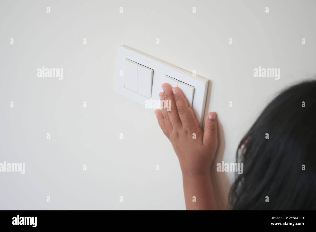 child finger turning on lighting switch with copyspace  Stock Photo
