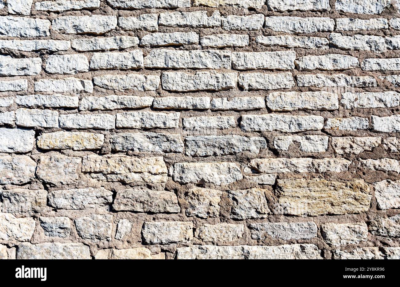 Ancient weathered rough stone wall as creative background. Grunge brick wall texture background Stock Photo