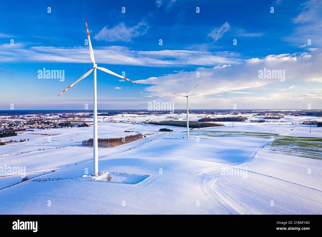 Wind turbine on snowy field in winter at sunrise. Aerial view of Poland ...