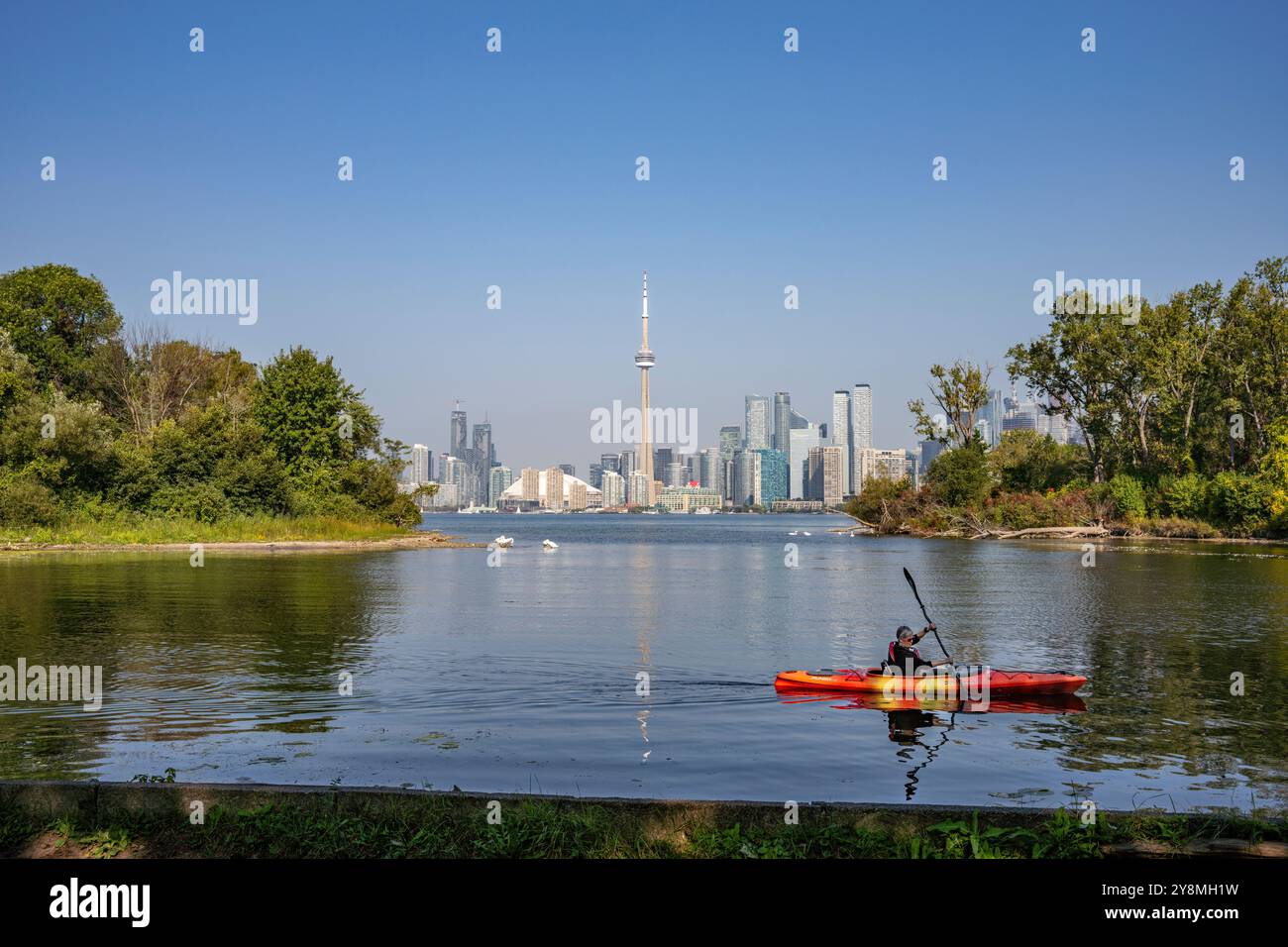 A lone kayaker on Lake Ontario, near Centre Island, with Toronto city skyline as background Stock Photo