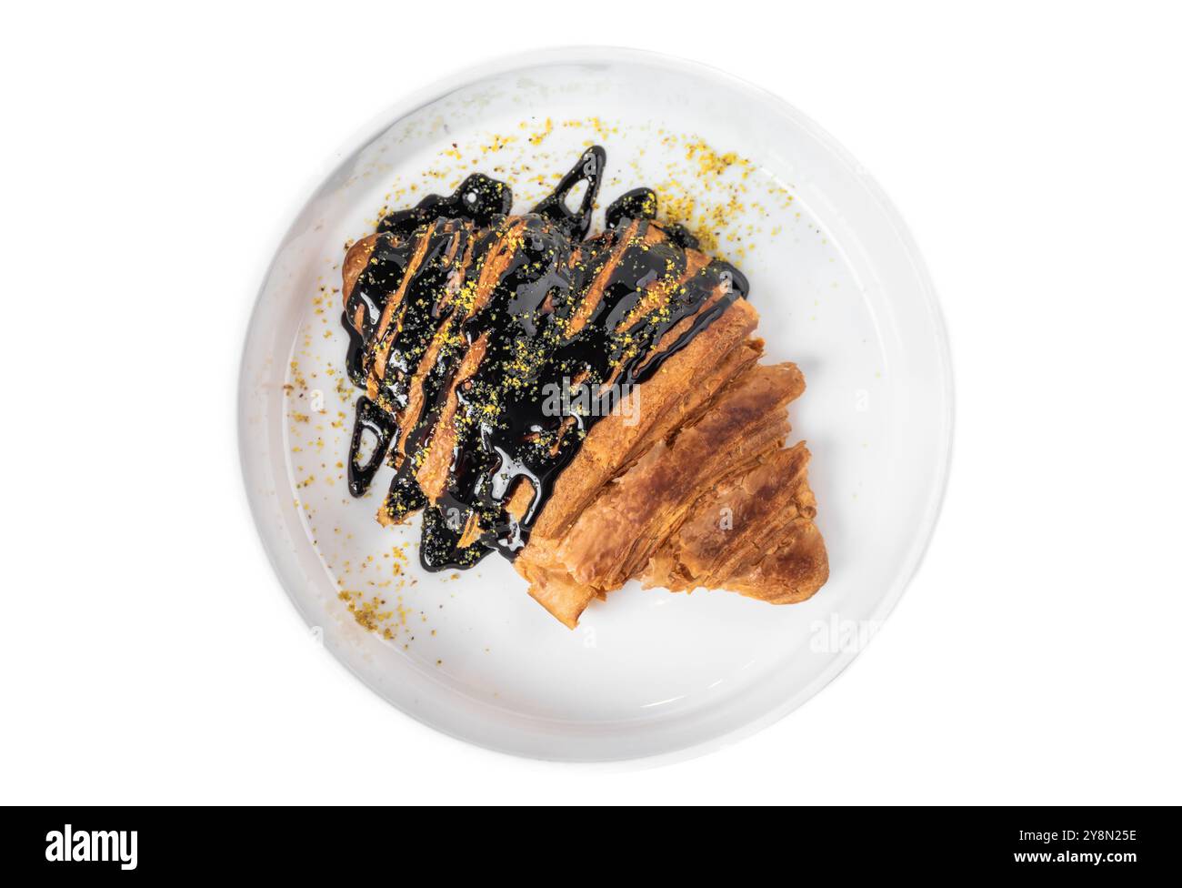 Sweet croissant with chocolate syrup in white plate on white background Stock Photo