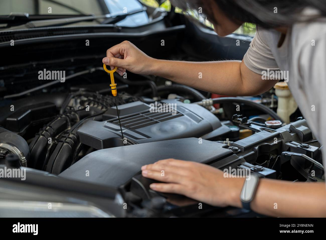 A young female checking a car Stock Photo