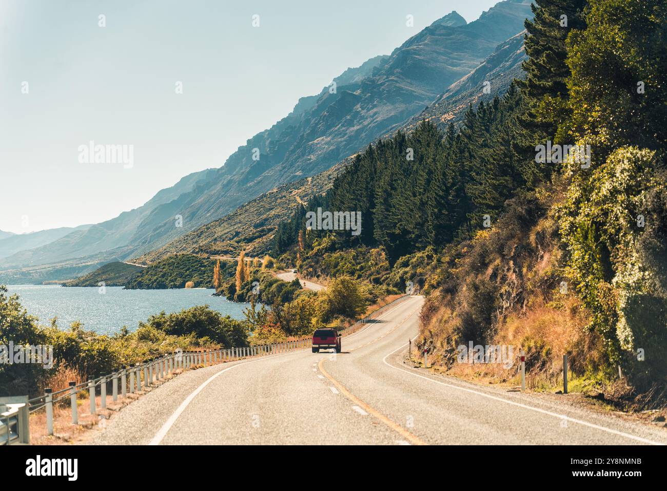 Rural scene with road trip car driving on the road in autumn forest at ...