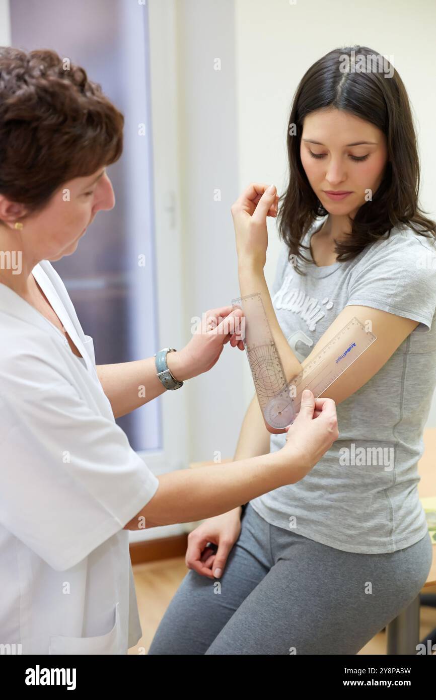 Doctor with goniometer measuring elbow flexion, Physiotherapy medical center, Donostia, San Sebastian, Gipuzkoa, Basque Country, Spain. Stock Photo