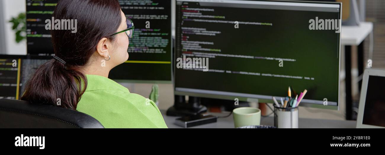Website header shot of female senior IT spetialist program coding on multiple screens in software development office, copy space Stock Photo