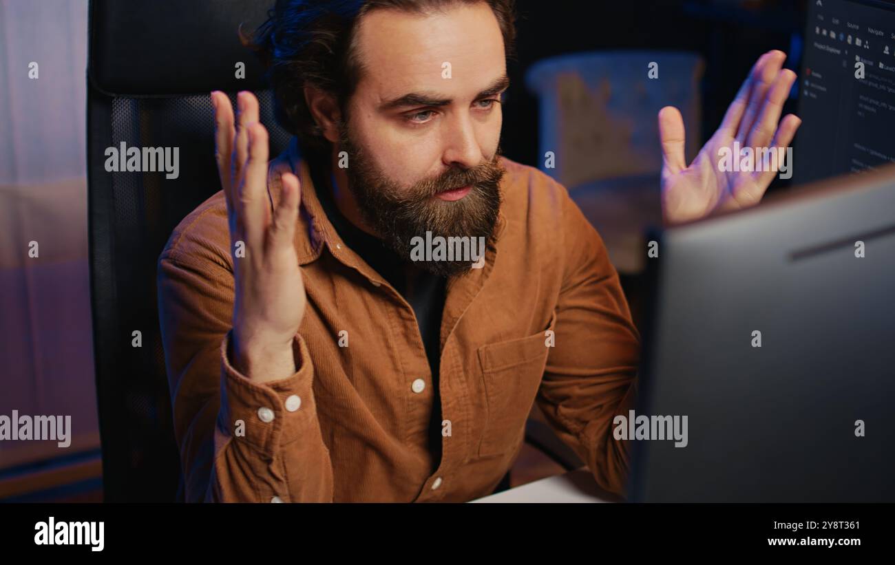 Disappointed computer scientist puzzled after being unable to remove all bugs while coding on workstation desktop. Teleworking IT specialist confused by troubling script errors, camera B close up Stock Photo