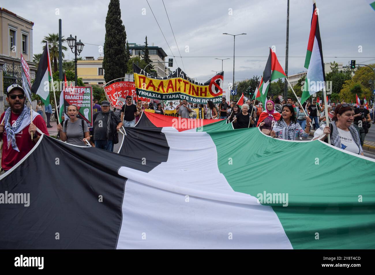 Athens, Greece. 5th Oct, 2024. Demonstrators hold a giant Palestine flag and shout slogans. Hundreds of protesters marched in the streets of Athens against wars and in solidarity with Lebanon and Palestine. (Credit Image: © Dimitris Aspiotis/Pacific Press via ZUMA Press Wire) EDITORIAL USAGE ONLY! Not for Commercial USAGE! Stock Photo