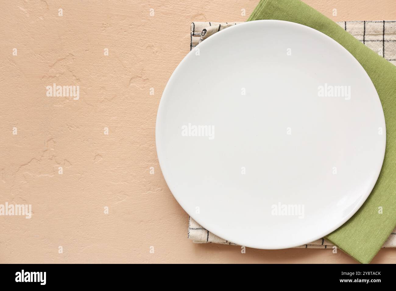 Table setting with plate and napkins on beige background Stock Photo
